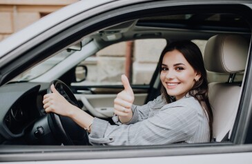 beautiful-young-latin-woman-driving-her-brand-new-car-showing-her-thumb-up-1-min-1